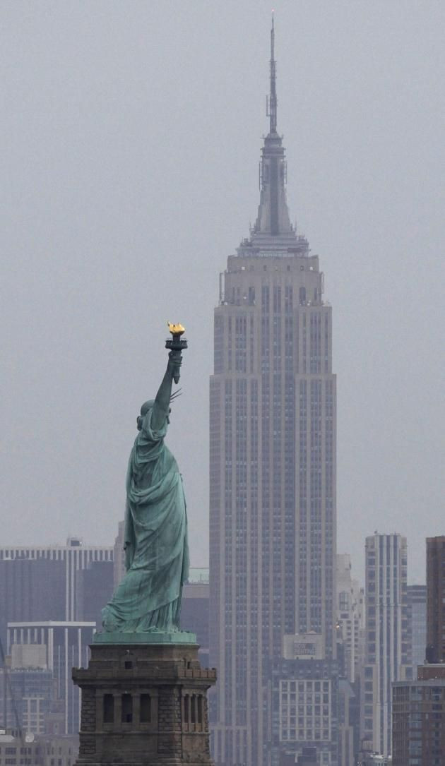 The Statue of Liberty as seen from Bayonne, with the Empire State building behind it.