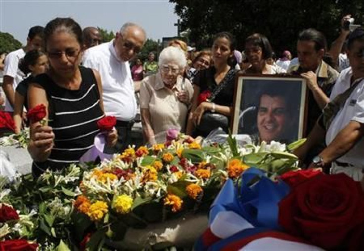 Ofelia Acevedo, wife of Oswaldo Paya, places a rose on her husband's tomb during his burial in July 2012.