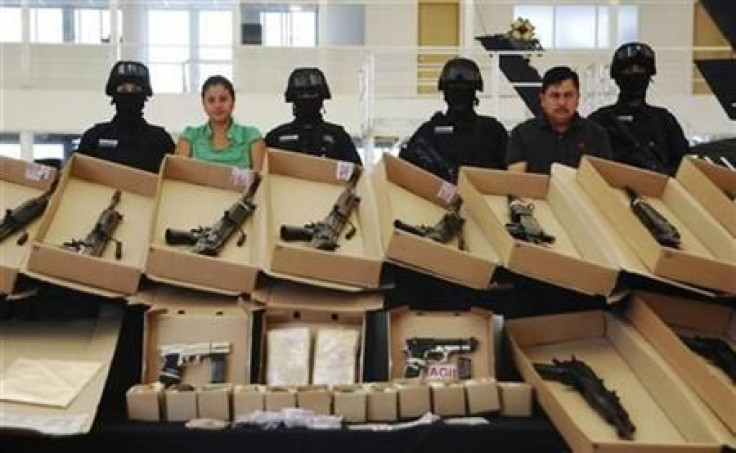 Mexican police display confiscated weapons and two arrested Zeta members in 2010.