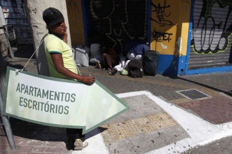 A woman holds a sign indicating where new apartments and offices can be found in Sao Paolo in 2011.