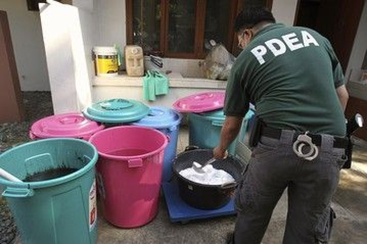 A Philippine Drug Enforcement Agency agent sifts through seized ingredients for methamphetamine in a town south of Manila.
