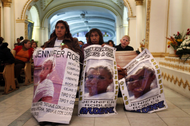Relatives and neighbors of 12 kidnapped youths hold banners during a mass at San Francisco de Asis church in Mexico City this August.
