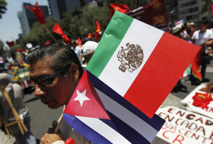 A man holds up a Cuban and Mexican flag in Mexico City in July during an event marking the 1953 Moncada military barracks assault in Cuba.