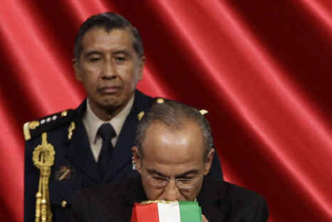 Former Mexican president Felipe Calderón kisses the presidential sash before handing it over to the incoming president Enrique Peña Nieto.