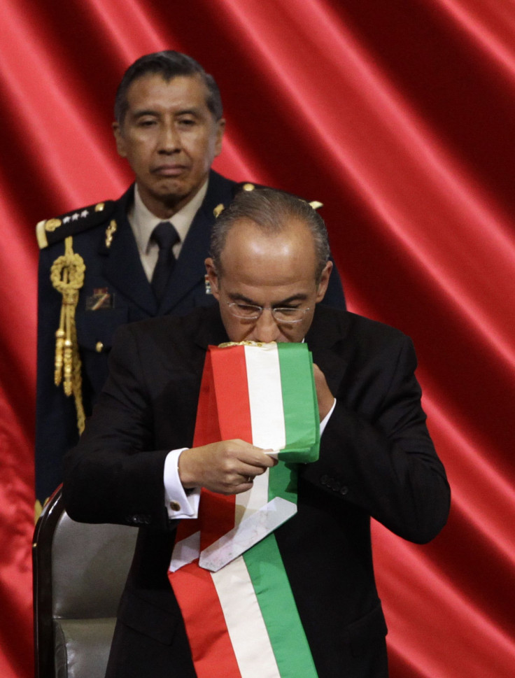 Former Mexican president Felipe Calderón kisses the presidential sash before handing it over to the incoming president Enrique Peña Nieto.