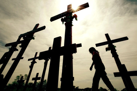 A woman walks past crosses erected in memory of women killed in Ciudad Juarez in Mexico's state of Chihuahua on the Mexico-United States border with El Paso, Texas, May 8, 2003