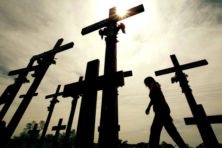 A woman walks past crosses erected in memory of women killed in Ciudad Juarez in Mexico's state of Chihuahua on the Mexico-United States border with El Paso, Texas, May 8, 2003