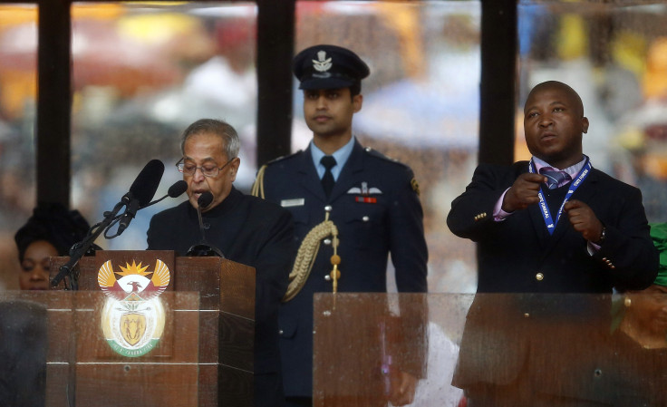 Thamsanqa Jantjie "signs" beside India's President Pranab Mukherjee at the memorial of late South African President Nelson Mandela at the FNB soccer stadium in Johannesburg December 10, 2013.