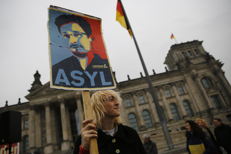 A protester holds a placard calling for Germany to give political asylum to Edward Snowden, outside the seat of the lower house of parliament, the Bundestag in Berlin November 18, 2013.