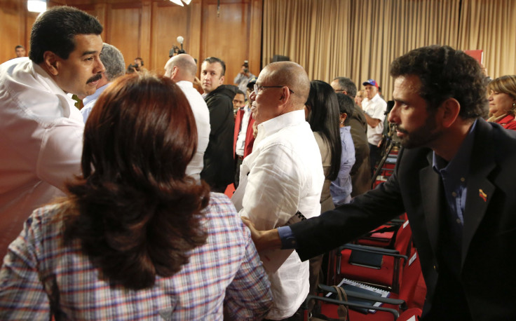 Maduro and Capriles shake hands.