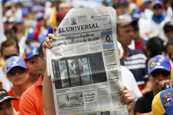 Opposition supporters hold up El Nacional.