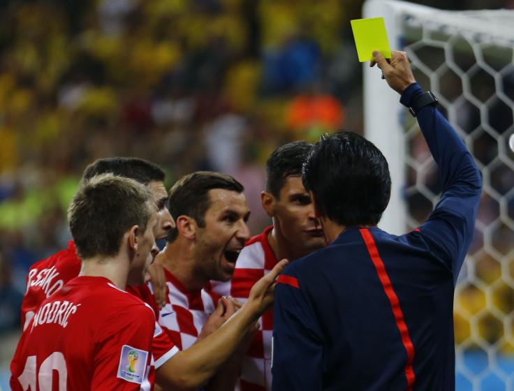 Referee Yuichi Nishimura gives yellow card