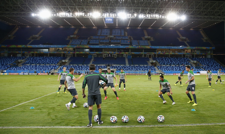 Australian soccer players warm up on the pitch