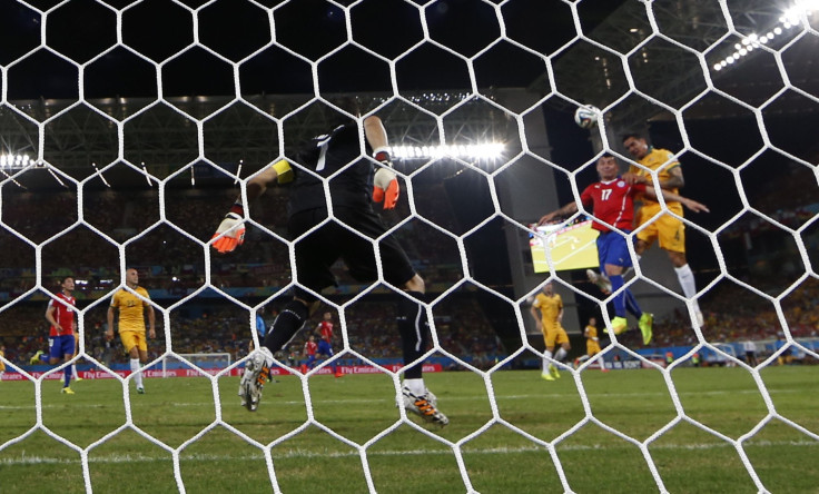 Australia's Tim Cahill (R) heads to score