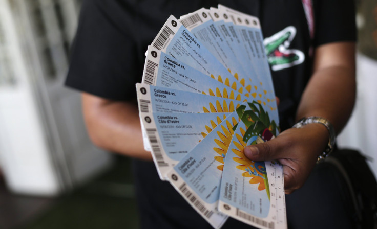A Colombian fan displays his FIFA 2014 World Cup tickets for the match between Colombia and Greece