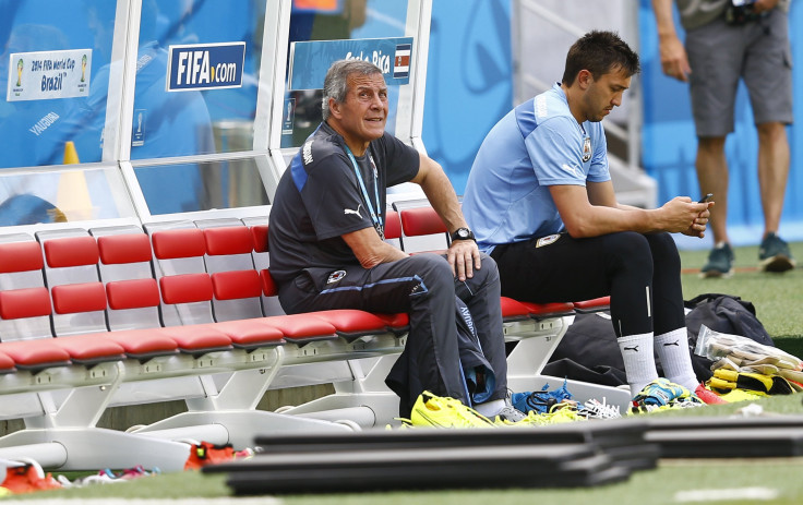 Uruguay's coach Oscar Tabarez (L) sits next to player Fernando Muslera