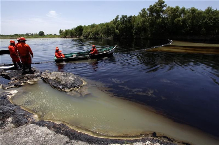 Technicians from PEMEX performing clean-up work in the San Juan River after a crude spill