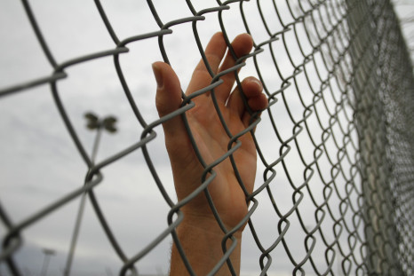 hand behind chainlink fence