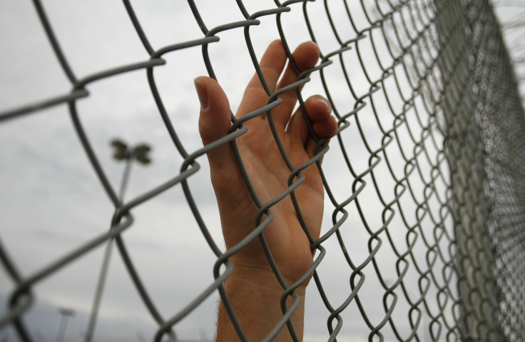 hand behind chainlink fence