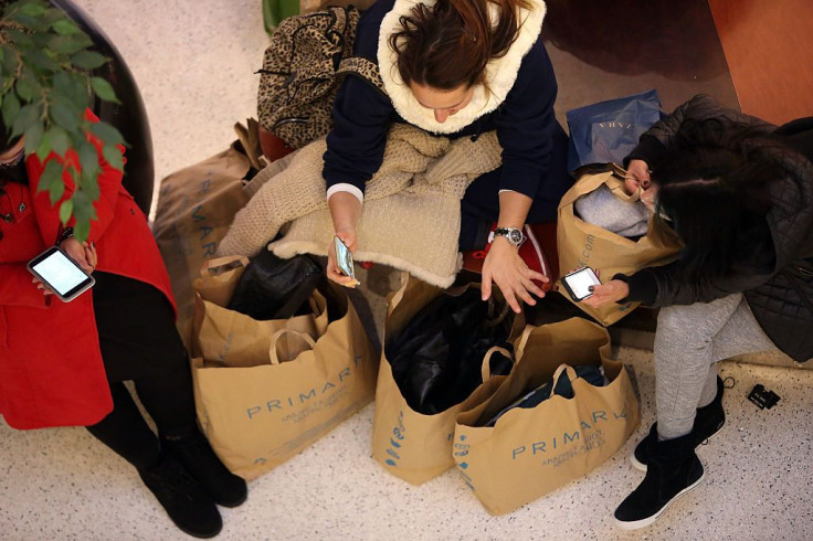 Visitors sit with shopping bags in a mall 