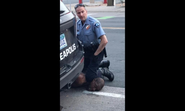 a-minneapolis-police-officer-holds-his-knee-to-AFP_1SE6IE