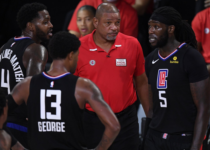 Doc Rivers of the LA Clippers talks with Montrezl Harrell #5 of the LA Clippers and Paul George #13 of the LA Clippers