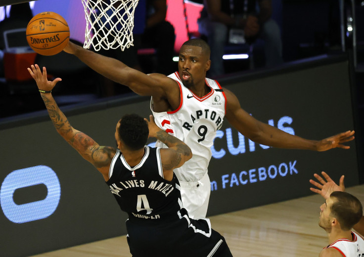 Serge Ibaka #9 of the Toronto Raptors fouls Chris Chiozza #4 of the Brooklyn Nets