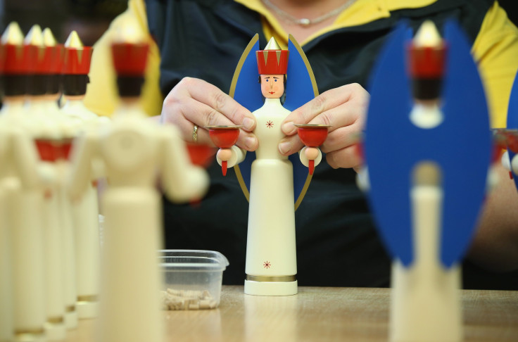 Artisan Annett Werner glues the wings onto a hand-crafted wooden figure of an angel that serves as a candle-holder at the Seiffener Volkskunst ateliers