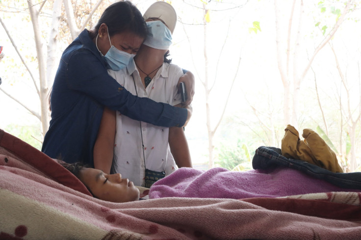 Family members grieve over the body of teenage bystander Tun Tun Aung at a cemetery in Mandalay on March 23, 2021, a day after he was shot dead in front of his home by security forces during a crackdown on demonstrations against the military coup.