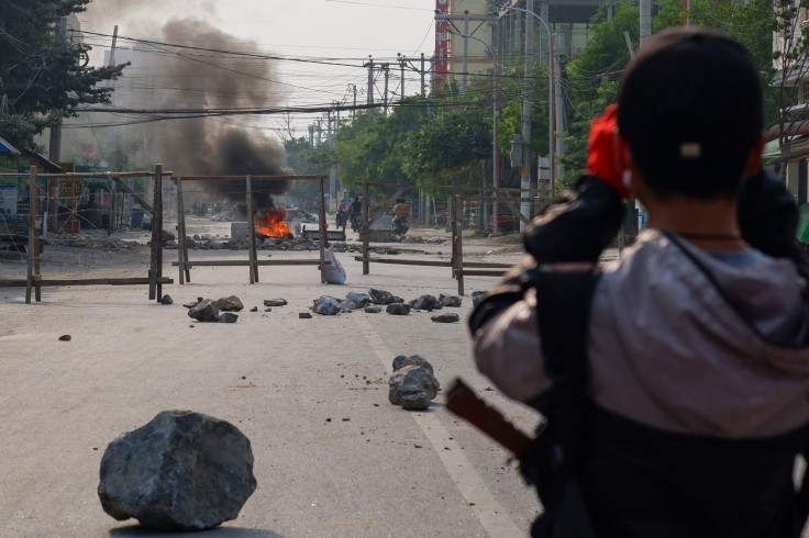 A protester watches a barricade of tyres burn, as security forces staged a crackdown on demonstrations against the military coup, in Mandalay on March 22, 2021.