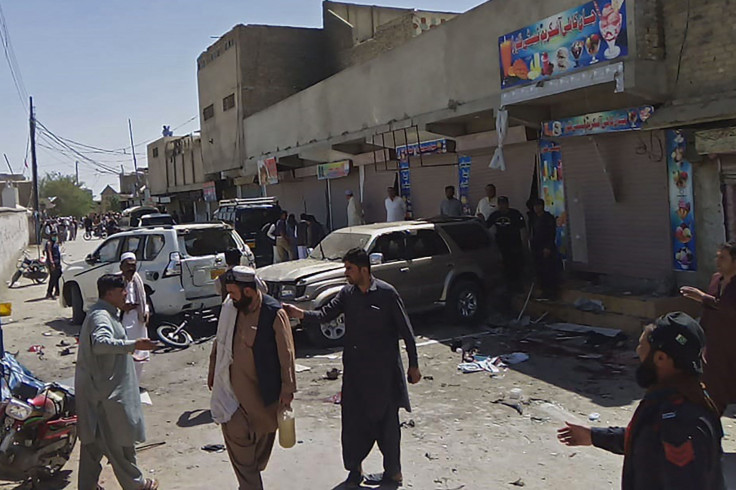 Security officials and onlookers are seen at the site of a bomb blast during a pro-Palestinian rally in which six people were killed and another 14 wounded, in Chaman of Pakistan's Balochistan province near the Afghanistan border on May 21, 2021.