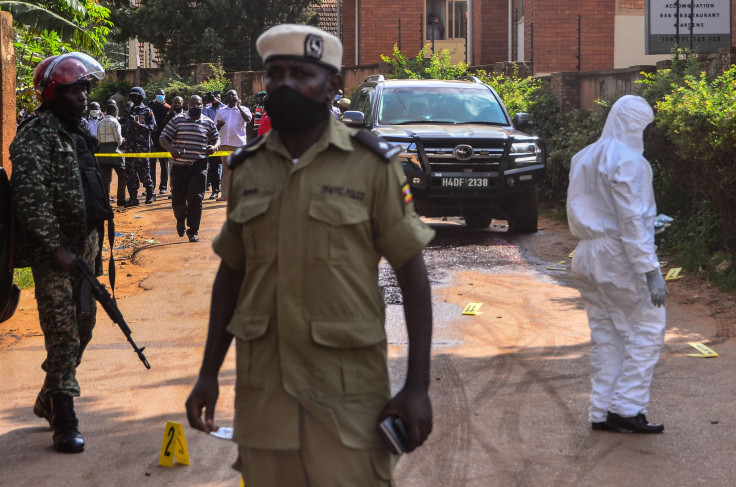 Police officers secure and investigate the crime scene with the car of Uganda's transport minister General Katumba Wamala in Kampala, Uganda, on June 1, 2021.