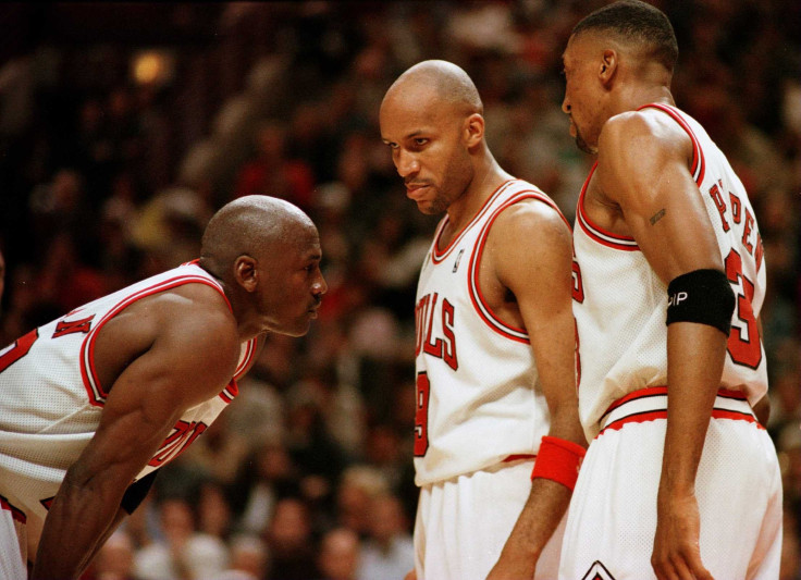 Michael Jordan of the Chicago Bull, left, discusses strategy with teammates Ron Harper, center, and Scottie Pippen during a time-out on the court during the fourth quarter of game two in the NBA Finals at the United Center