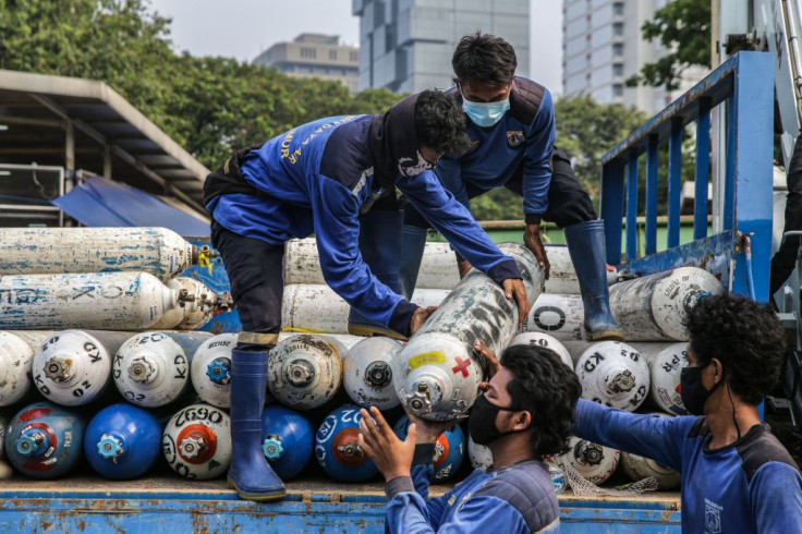 Workers unload oxygen tanks