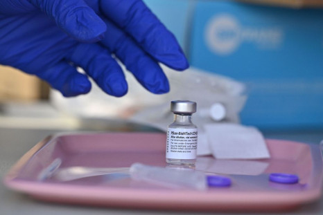 A nurse reaches for a vial of Pfizer-BioNTech Covid-19 vaccine at a pop up vaccine clinic 