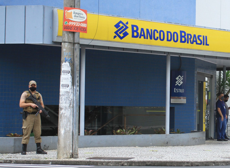 A police officer stands guard outside the bank which robbers struck just after midnight, in Criciuma, Brazil, on December 1, 2020. 