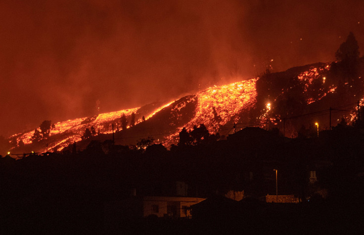 Lava flows approach houses as the Mount Cumbre Vieja erupts in El Paso, spewing out columns of smoke, ash and lava as seen from Los Llanos de Aridane on the Canary island of La Palma, on September 19, 2021. 