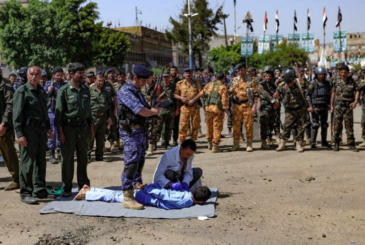 A member of the Yemeni security forces prepares to execute one of nine men