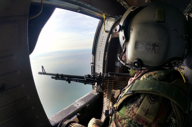 A Colombian Army soldier sits in a helicopter overflying the area where drug lord Dairo Antonio Usuga was captured