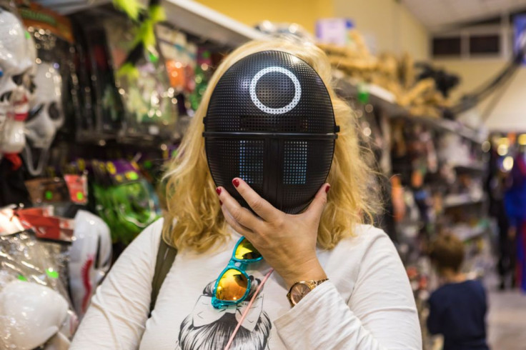 A woman poses with a mask from the Netflix TV series 'The Squid Game' 