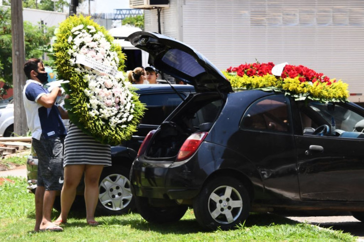 A couple unloads a wreath of flowers for Brazilian singer Marilia Mendonca