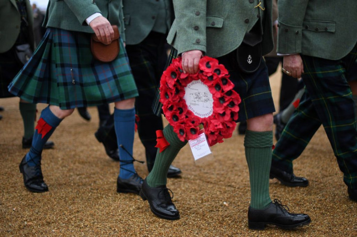 A veteran carries a poppy wreath as he attends Remembrance Sunday