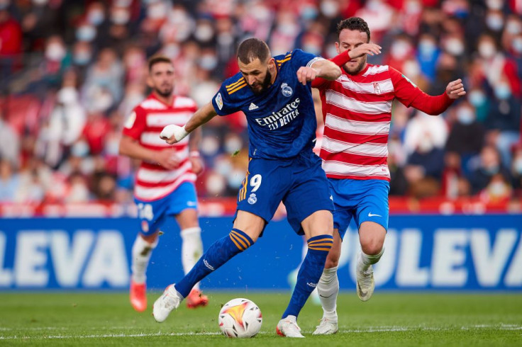 Quini of Granada CF competes for the ball with Karim Benzema of Real Madrid