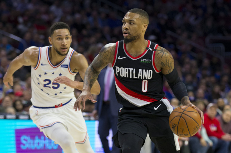 Damian Lillard #0 of the Portland Trail Blazers dribbles the ball against Ben Simmons #25 of the Philadelphia 76ers