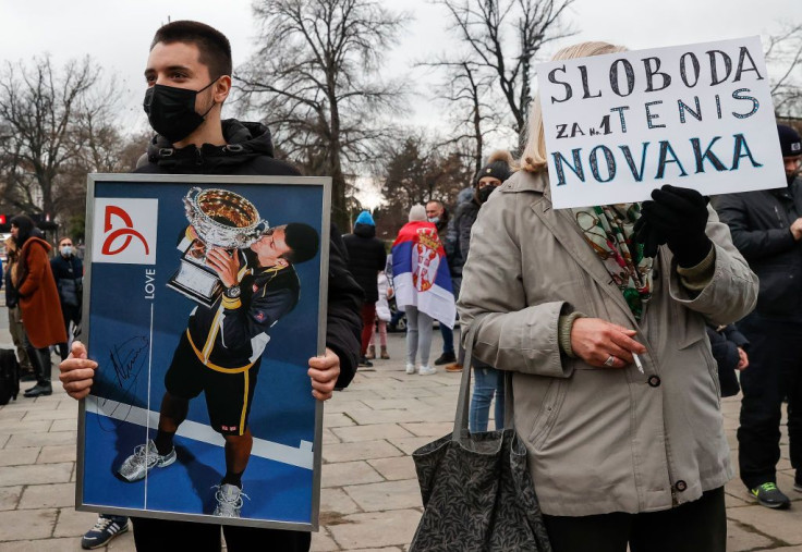 Demonstrators pose with a placard picturing Serbian tennis player Novak Djokovic