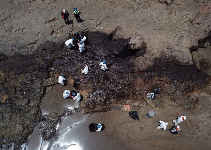 Aerial view showing cleaning crews work to remove oil from a beach in the Peruvian province of Callao on January 17, 2022