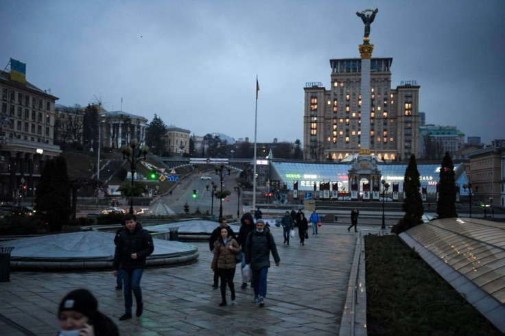People walk in central Kyiv in front of the Independence Monument