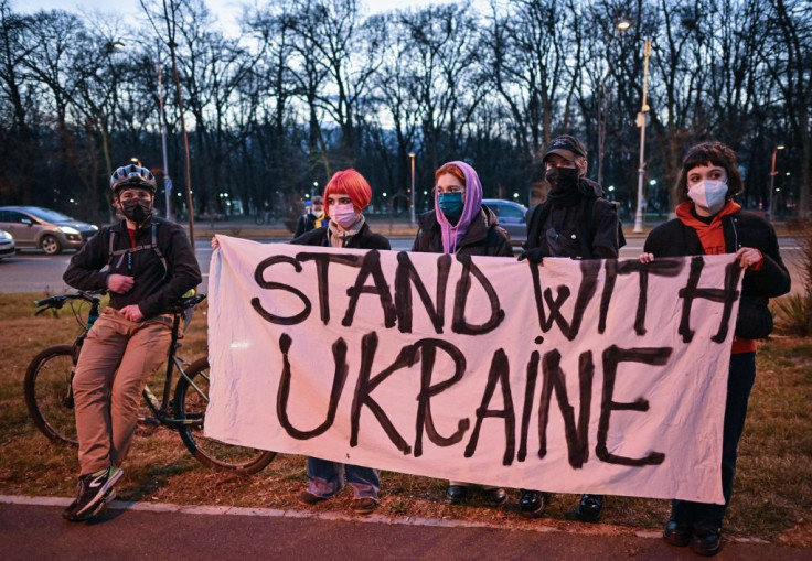 People hold a banner reading 'Stand with Ukraine' during a rally 