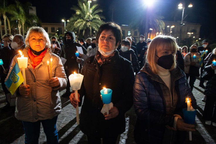 Demonstrators hold candles during a vigil 