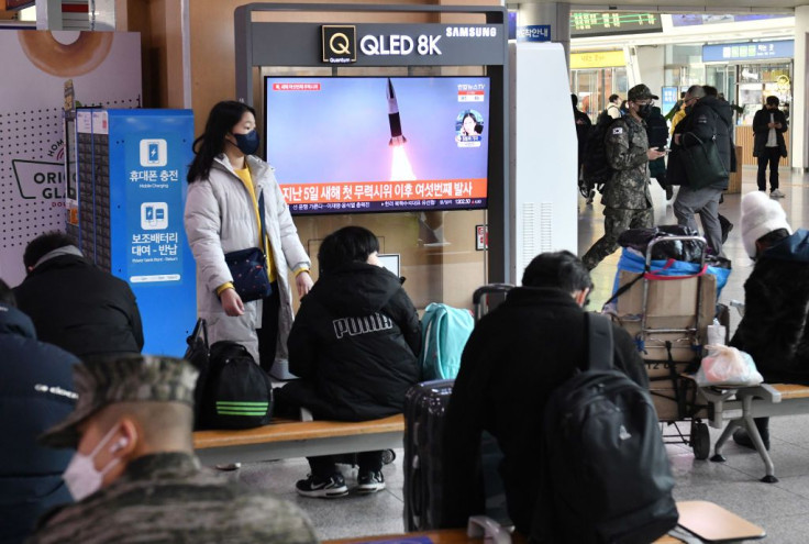 TV screen shows a news broadcast with file footage of a North Korean missile test